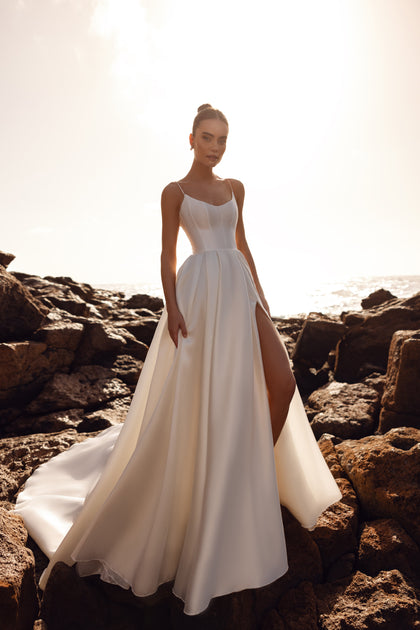 Alya bridal dress made of matte satin with a corset top and thin straps, offering minimalist elegance from the front.