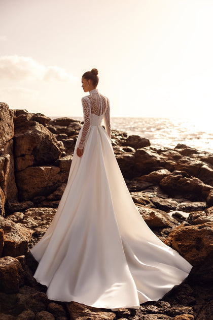 From behind, Alya shows a softly draping train and a subtle back design, highlighting the classic silhouette and ease.