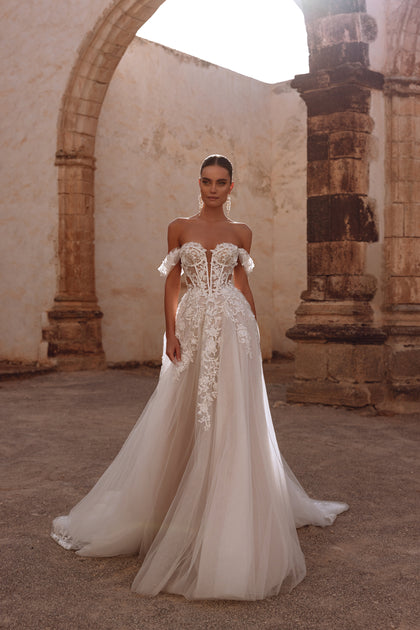 Ariella bridal dress has a corset with visible boning and intricate floral lace appliqués, offering a delicate, ethereal elegance.