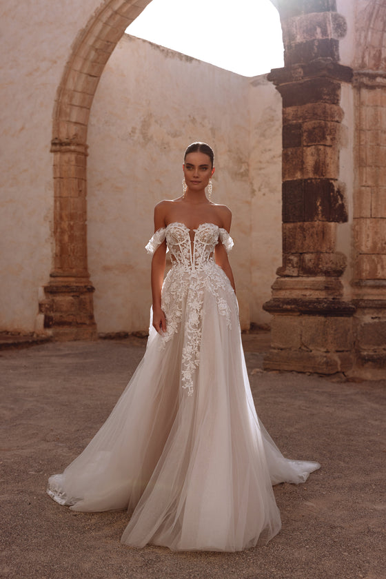 Ariella bridal dress has a corset with visible boning and intricate floral lace appliqués, offering a delicate, ethereal elegance.