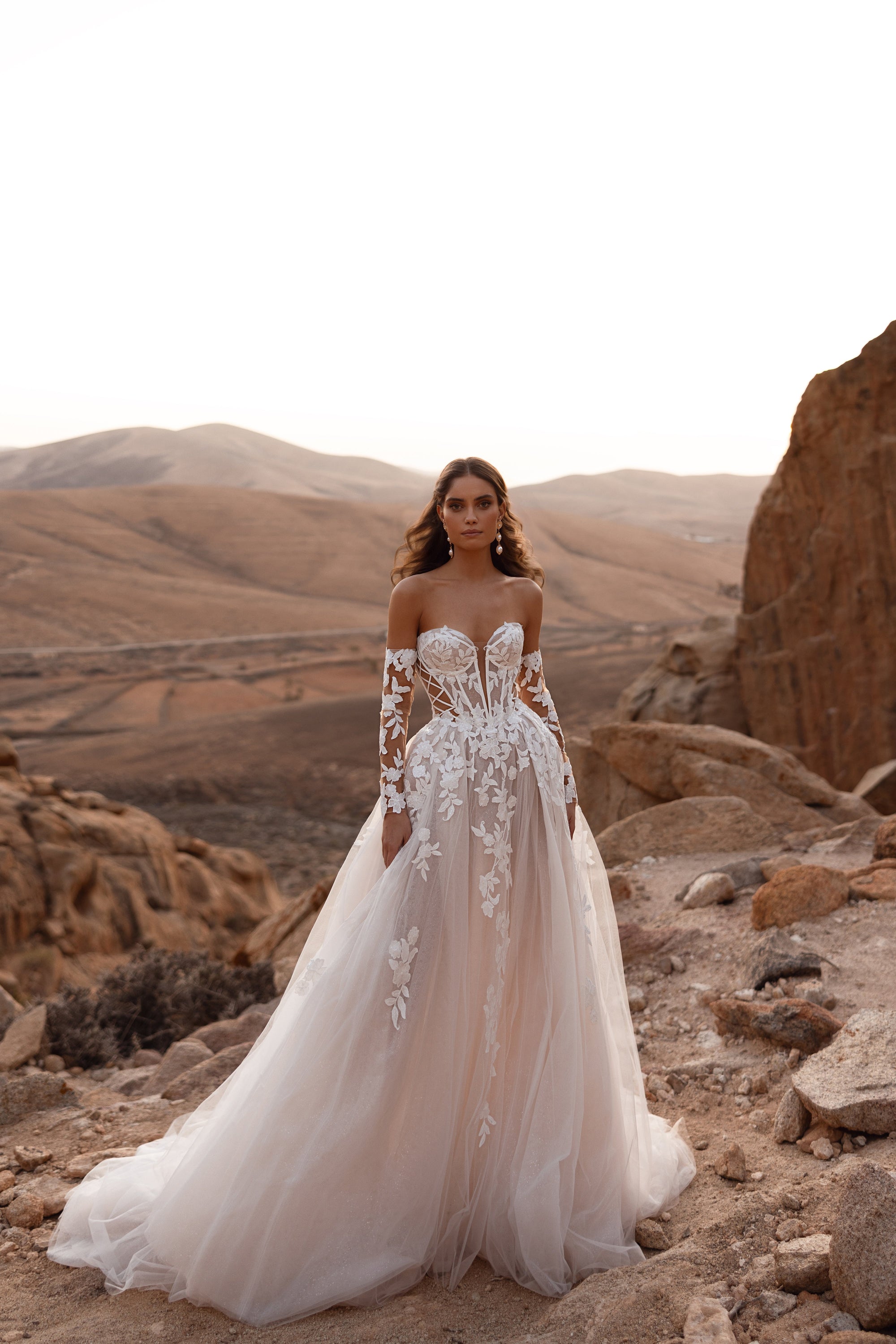 The Nabila wedding dress with a long cathedral veil and lace sleeves exudes timeless bridal elegance and luxury craftsmanship.