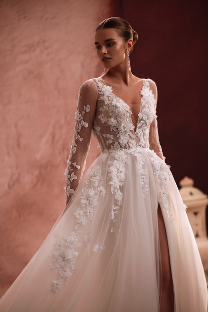 Semiramida bridal dress has a translucent corset with floral embroidery and three-dimensional appliqués, offering a romantic and airy aesthetic.