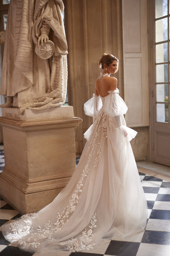 Full-length back view of Estella wedding dress, with floral lace over the tulle skirt and long train