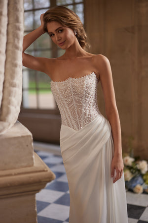 Greta wedding dress – a richly beaded strapless corset and draped satin skirt.
