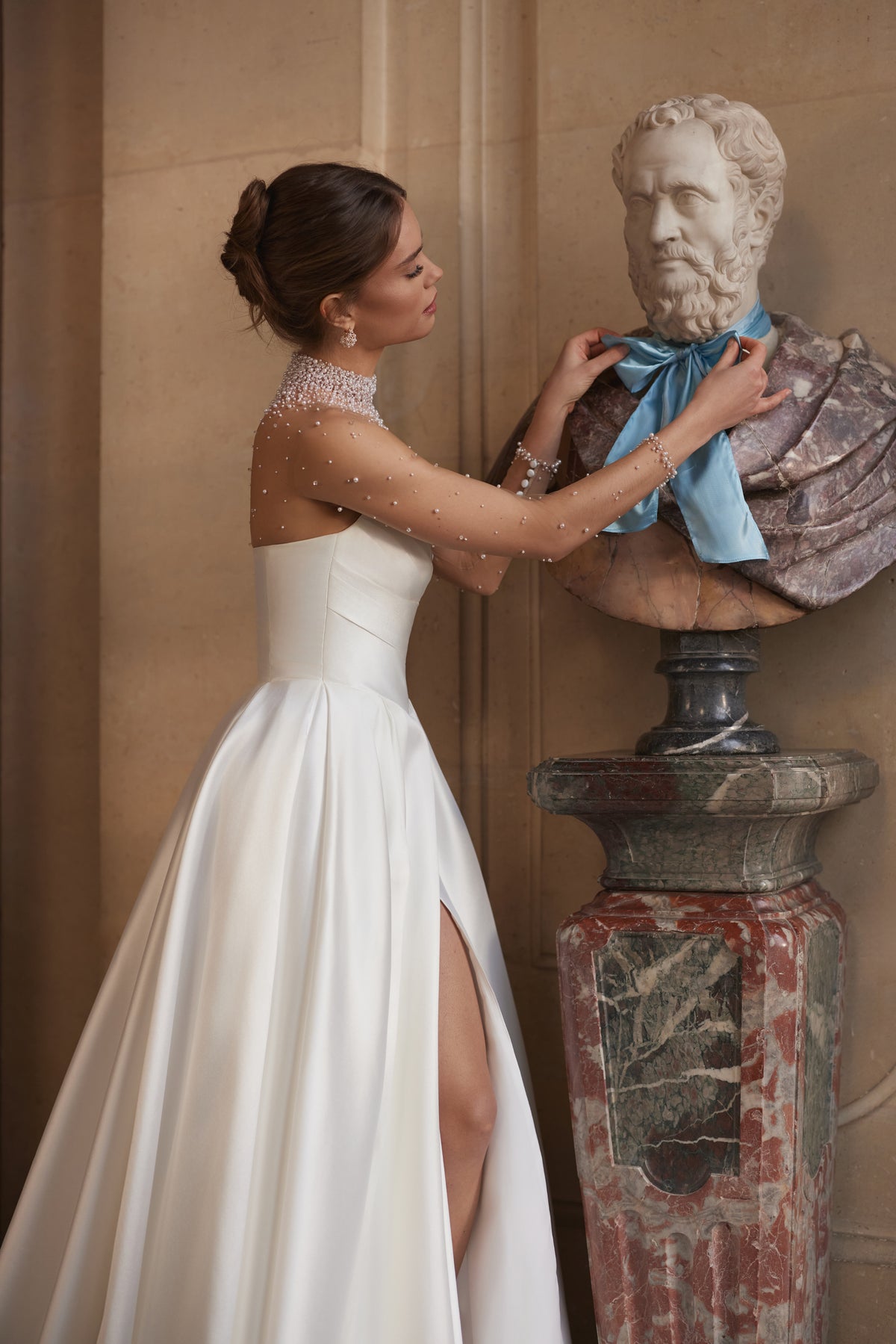 Lucienne wedding dress – a crystal-embellished illusion neckline and draped satin skirt with a high slit.