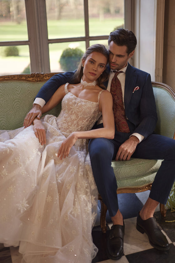 Bride seated beside the groom on a sofa in Milkyway wedding dress, with star-embroidered tulle