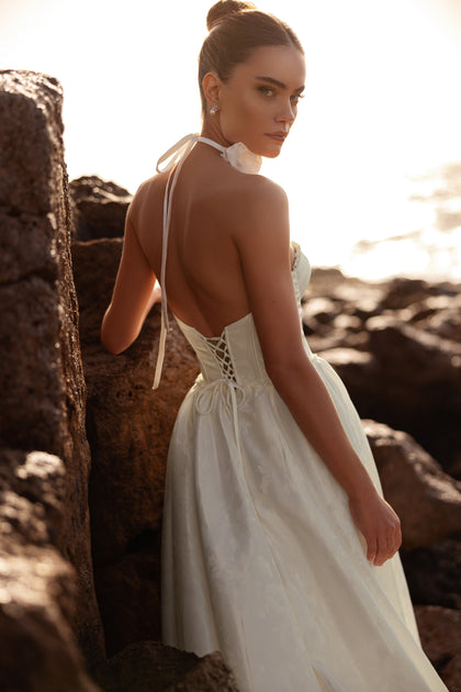 Back view of the Cholly wedding gown with lace-up corset and low back design, highlighting an elegant yet sensual look.