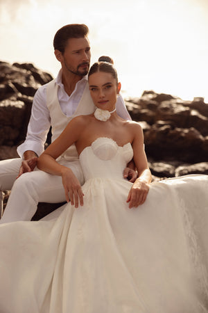 The Cholly wedding gown in satin finish with a structured bodice and full skirt, captured in a romantic seaside shoot.