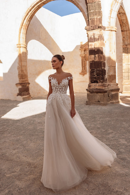 The Andrea wedding gown with off-the-shoulder lace bodice and airy tulle skirt highlights delicate bridal elegance.