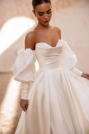 The back of Anika satin wedding gown highlights the bride’s silhouette with soft folds and minimalist elegance.