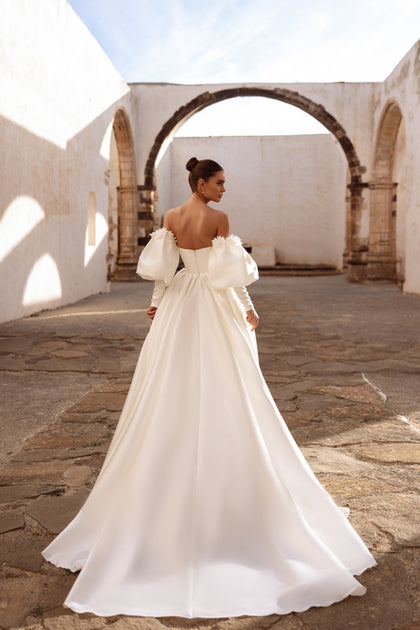 Stunning full-length wedding dress Anika with off-shoulder sleeves and elegant train for a royal bridal style.