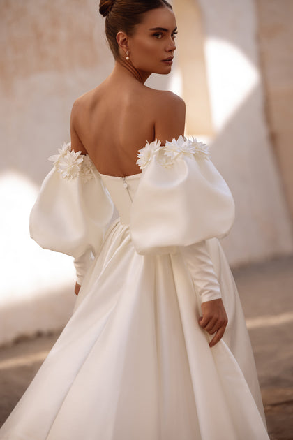 Modern romantic wedding dress Anika with long puff sleeves and floral details for a unique bridal look.