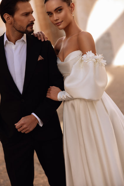 Romantic satin wedding gown Anika with sweetheart neckline and voluminous skirt glowing under natural sunlight.