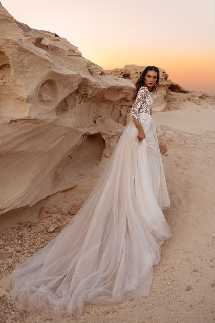 The Armori wedding dress features a deep neckline and 3D floral lace bodice, blending modern style with timeless romance.