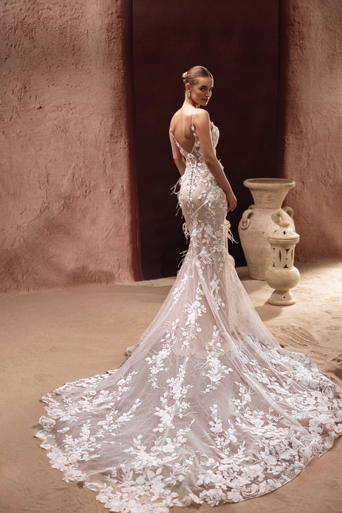 The Aspasia wedding dress features a low back and embroidered lace train, blending sensuality with timeless bridal beauty.