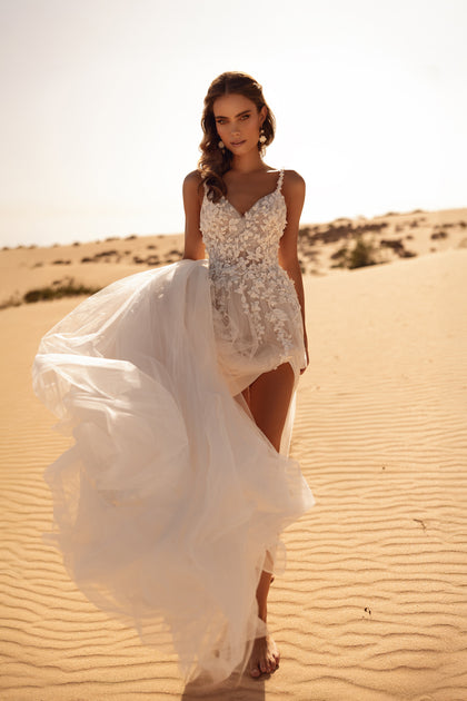 The Aviva wedding dress with a plunging neckline and lace straps combines soft sensuality with bridal sophistication.