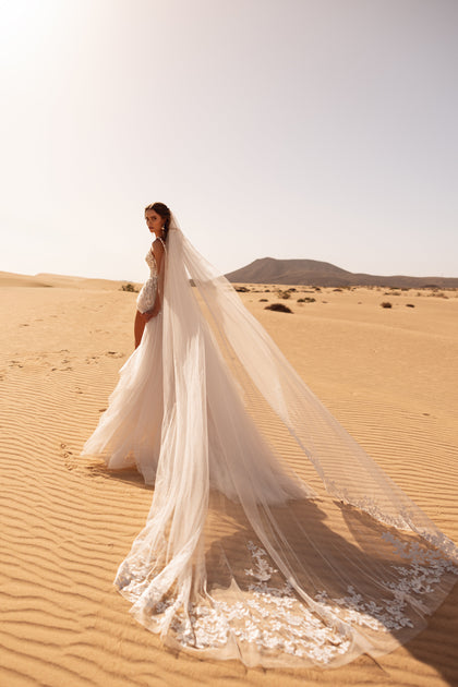 The Aviva wedding veil with lace edging adds a stunning finishing touch to the romantic bridal ensemble.