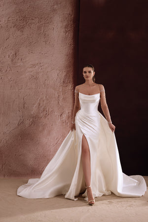 The Aylin satin wedding dress with a thigh-high slit and fitted mermaid silhouette blends modern glamour and classic grace.