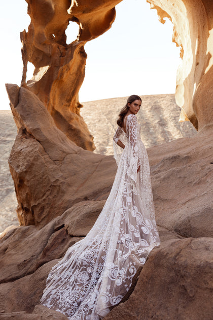 The back of the Dune wedding gown showcases intricate lace embroidery and a flowing cathedral train.
