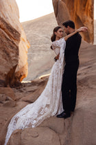 The Dune wedding dress with a lace train captures the intimacy and romance of a desert-inspired love story.