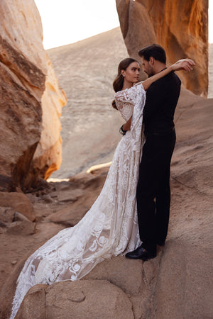 The Dune wedding dress with a lace train captures the intimacy and romance of a desert-inspired love story.