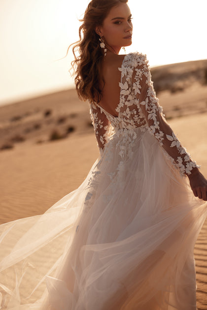 The Farida wedding gown glows in sunset light, showcasing its 3D floral lace and ethereal tulle layers.