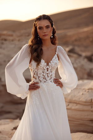 The Judith wedding dress features a lace bodice with airy chiffon sleeves, perfect for a romantic boho bride.