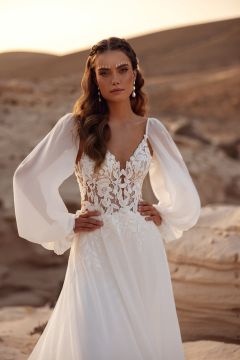 The Judith wedding dress features a lace bodice with airy chiffon sleeves, perfect for a romantic boho bride.