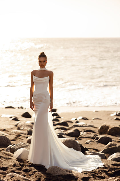 The Luna wedding gown with open back and long satin ribbons embodies timeless elegance and sensual style.