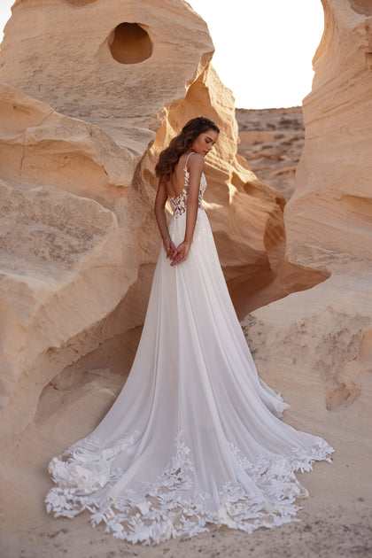 The Malika wedding gown features a breathtaking floral lace train that adds movement and elegance.