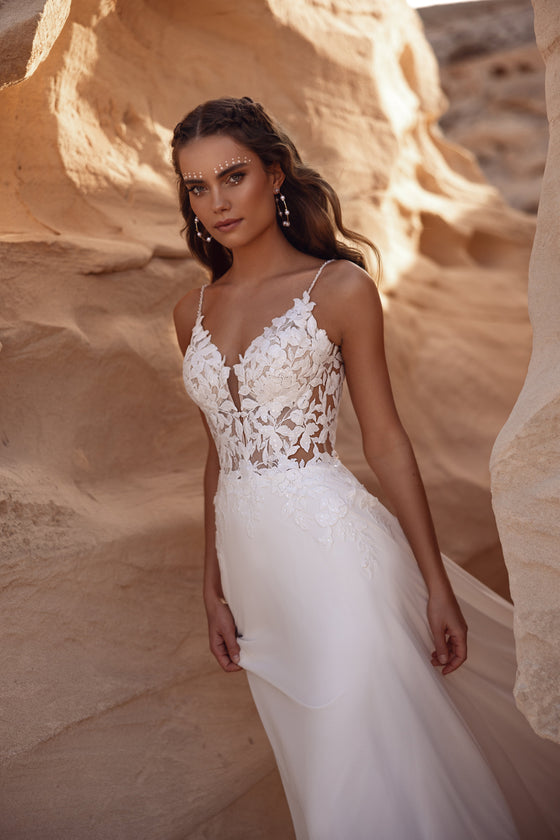 The open back of the Malika boho wedding dress adorned with lace details highlights a feminine silhouette.