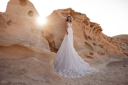 The Malika wedding dress features a sweetheart neckline and sheer lace bodice for a sensual boho bridal look.