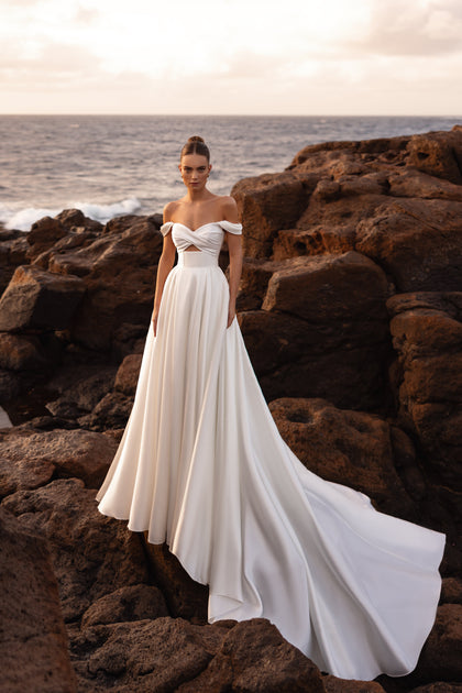 Mellisandre off-the-shoulder ball gown wedding dress with a flowing train, ideal for a romantic and royal bridal look.