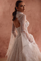 The Michelle bridal lace bolero with long sleeves in haute couture style adds a unique touch to the bridal look.