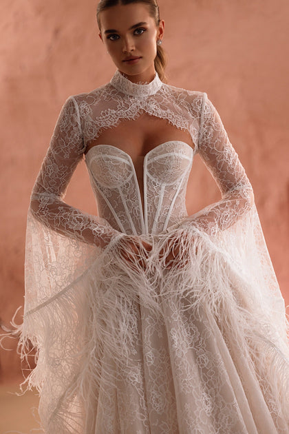 The Michelle wedding dress features an open lace back and sheer sleeves with feathers, radiating timeless elegance.