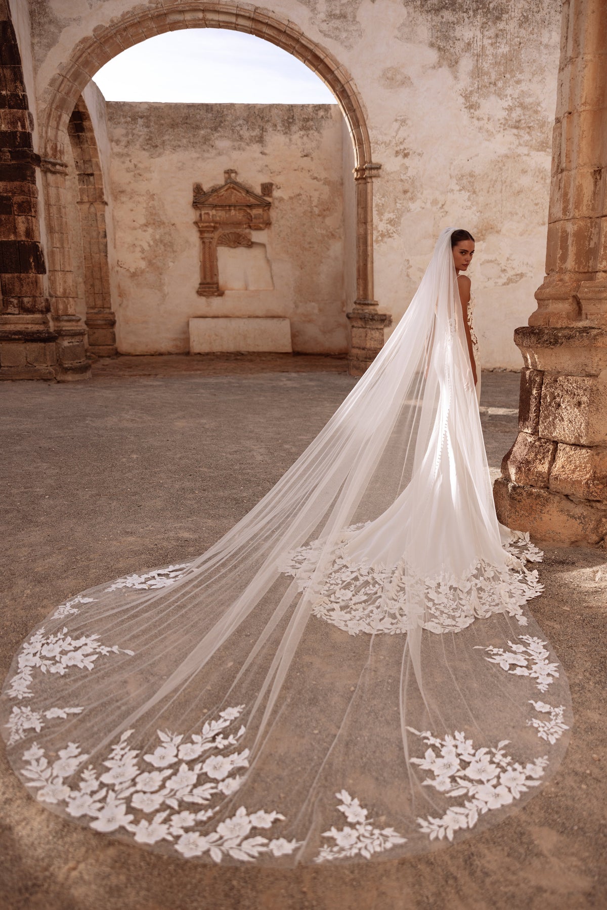 The Munira cathedral-length veil with embroidered floral edges delivers a majestic, glamorous bridal look.