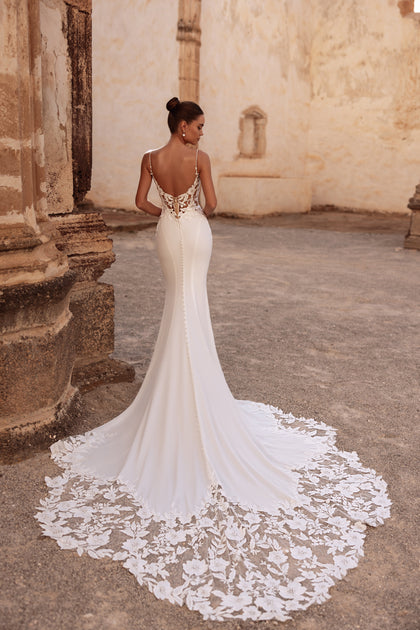 The Munira wedding gown with a fitted silhouette and lace train perfectly blends classic elegance with modern allure.