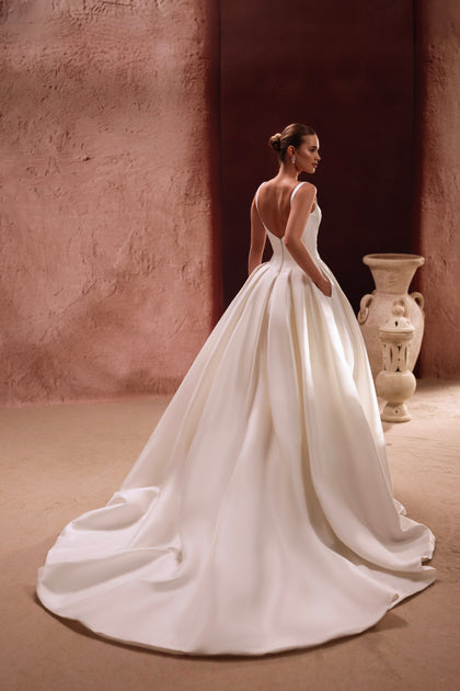 The Nicolette wedding gown with a full chapel train embodies royal elegance and timeless bridal glamour.
