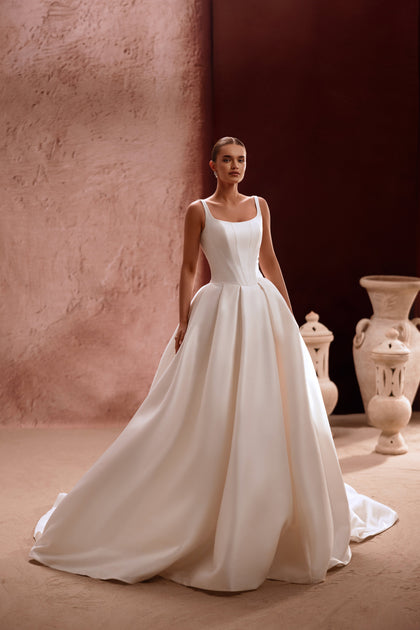 The Nicolette wedding gown with a square neckline and structured bodice flatters the figure with effortless elegance.