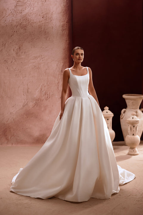 The Nicolette wedding gown with a square neckline and structured bodice flatters the figure with effortless elegance.