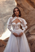 The Oasis lace wedding dress with puff sleeves and sheer tulle skirt blends vintage romance with couture-inspired elegance.