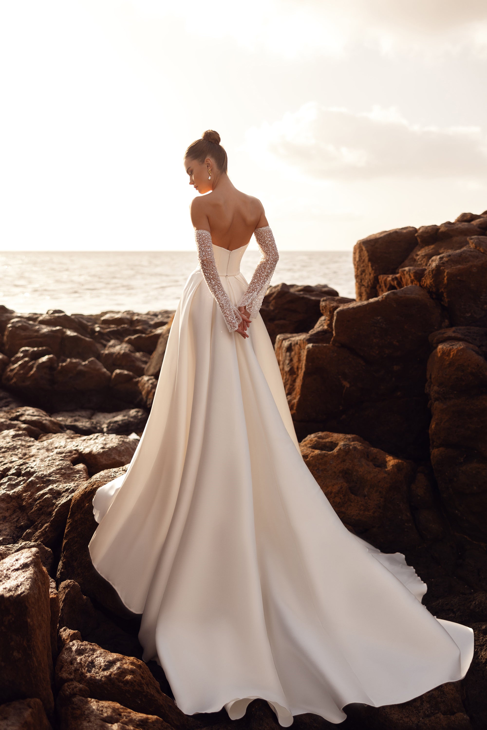 The strapless Sarabi wedding gown with pearl-embellished gloves creates a luxurious and glamorous bridal look.