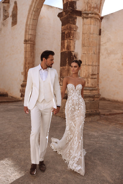 The Sarifa strapless wedding gown with sweetheart neckline and floral appliqués captures romantic sophistication.