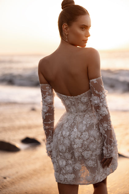 The Kayla wedding dress with a sweetheart neckline and lace embroidery enhances feminine curves in a sunset glow.