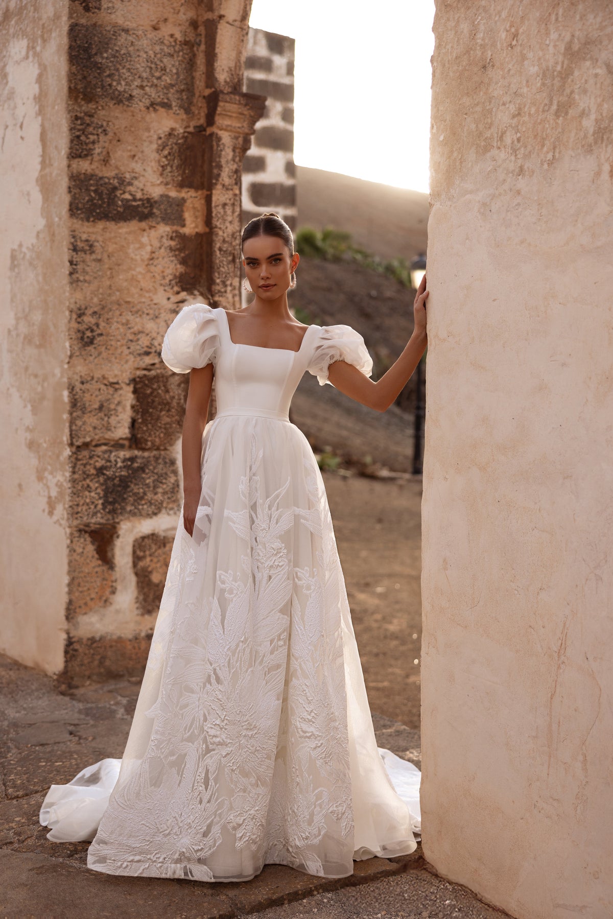 The Vanilla wedding gown with an open back and bow detail beautifully highlights the bride’s silhouette.