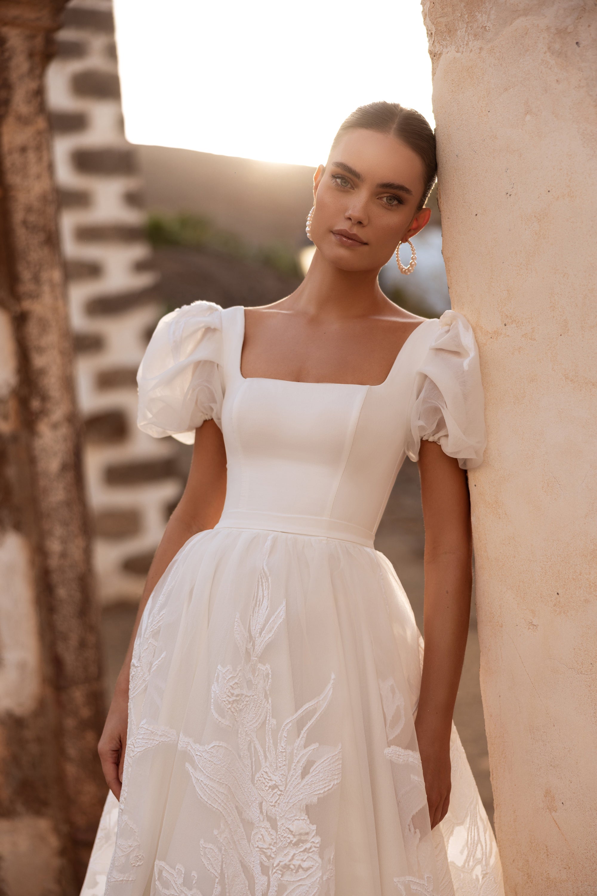 The Vanilla wedding dress with puff sleeves and a square neckline brings a royal-inspired yet modern bridal look.